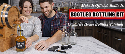Couple bottling homemade whiskey using the Bootleg Bottling Kit complete home bottle filling and corking solution with glass bottles and tools on kitchen counter