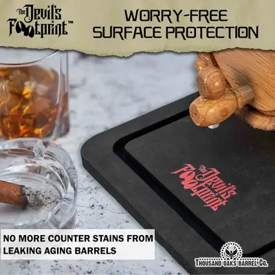 Barrel aging mat preventing counter stains from leaking whiskey barrel on kitchen island.